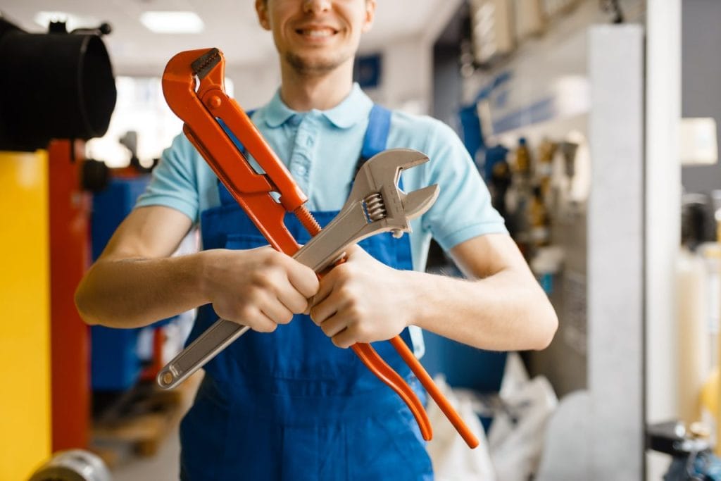 plumber-poses-with-pipe-wrenches-plumbering-store